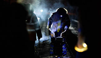 Workers examine railway track before dawn due to cold weather in NE China